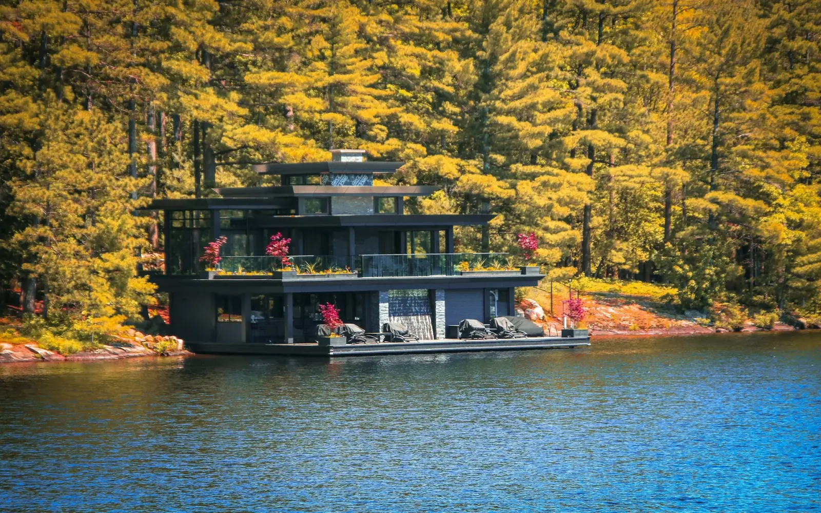 Autumn trees and a boathouse on a calm lake in Muskoka, Ontario