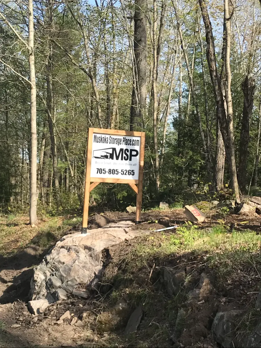 Muskoka Storage Place entrance sign among trees and Canadian Shield rock in MacTier, Ontario